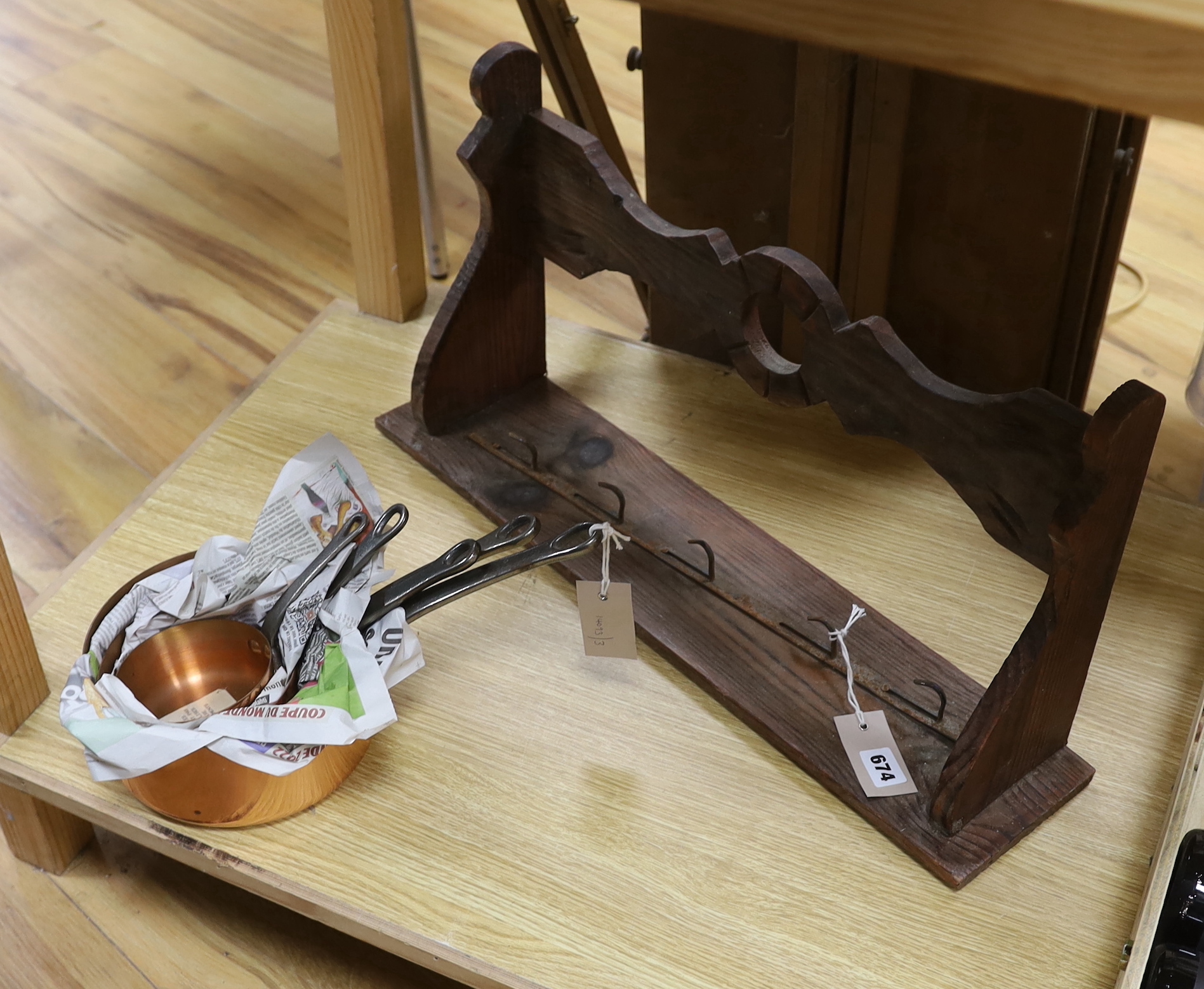 A graduated set of five French copper and cast iron saucepans with hanging rack, 60cm wide